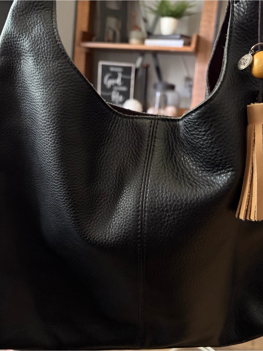 The Sak Black Pebbled Leather Hobo Shoulder Bag with Tan Tassel Charm
